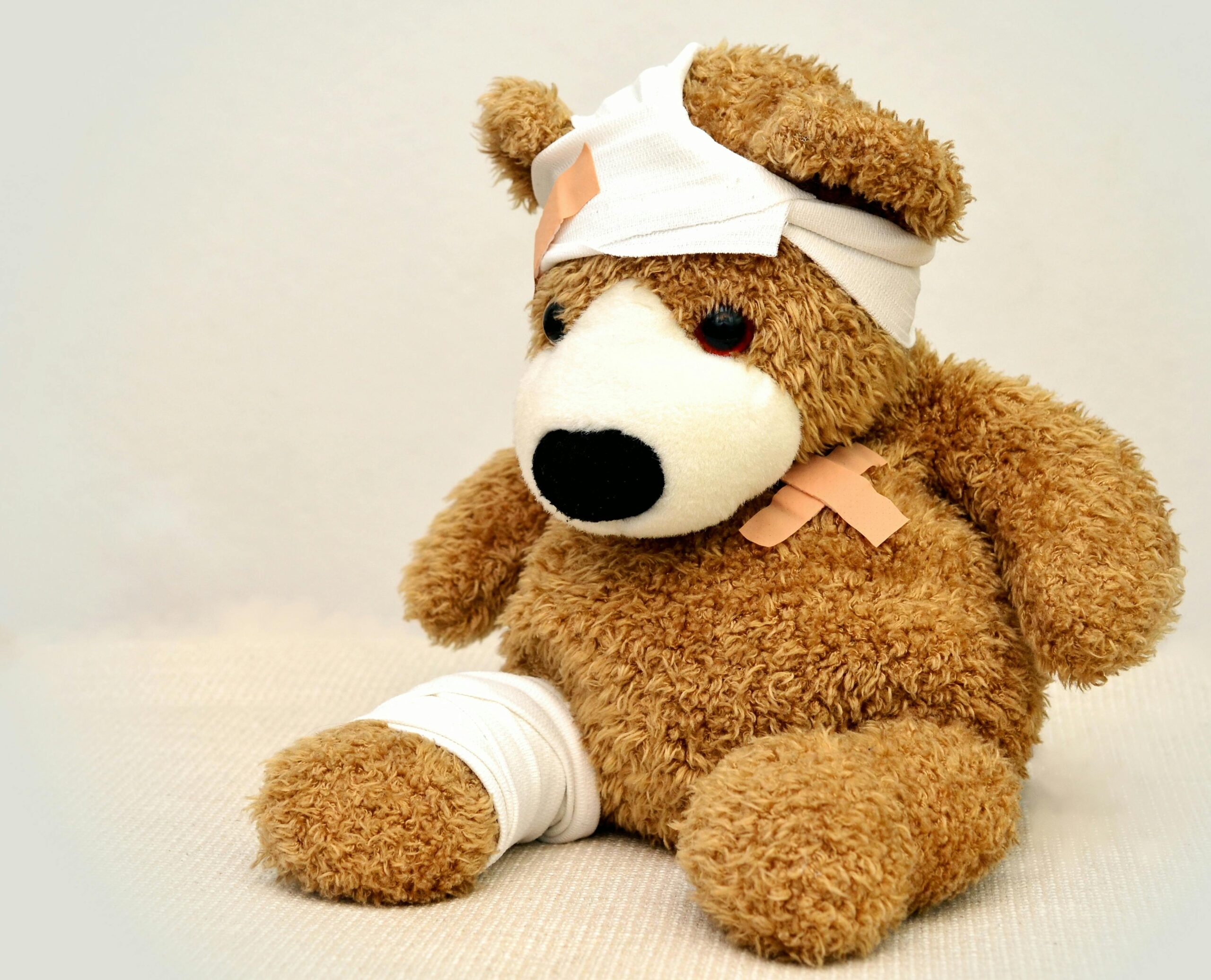 Teddy bear with bandages on head and leg