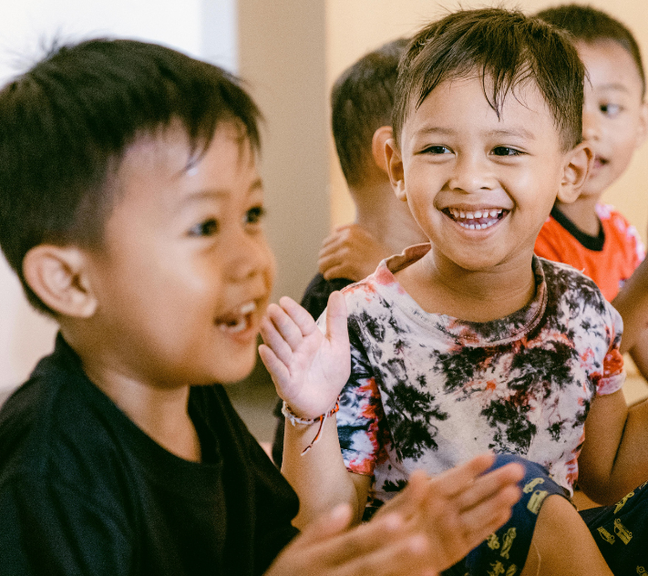 Two boys smiling while clapping hands