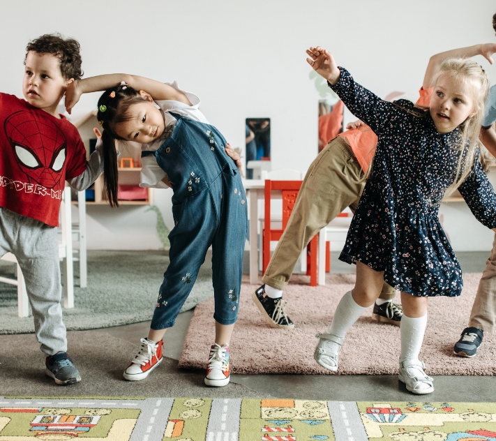 Young children standing and stretching.