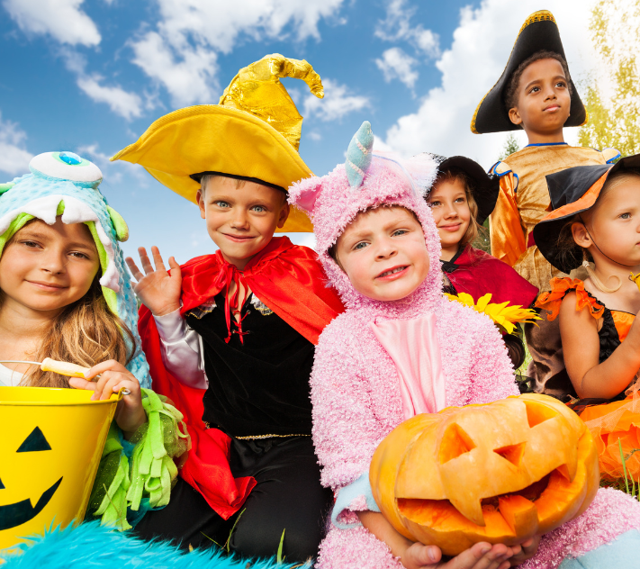 Young kids in halloween costumes with their trick-or-treat pales.