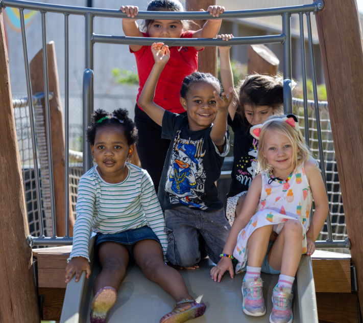 Young preschool children hanging out on a playset